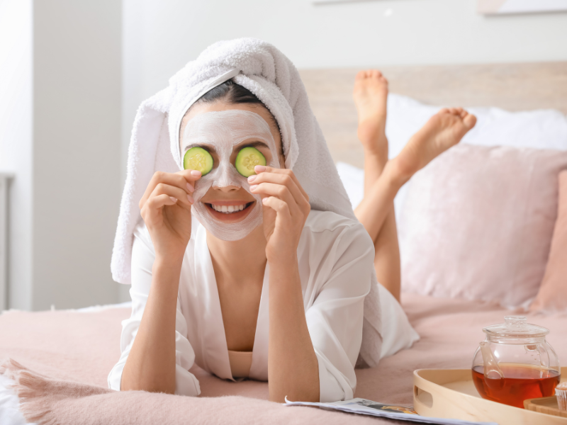 Girl with face masks on and cucumbers on her eyes